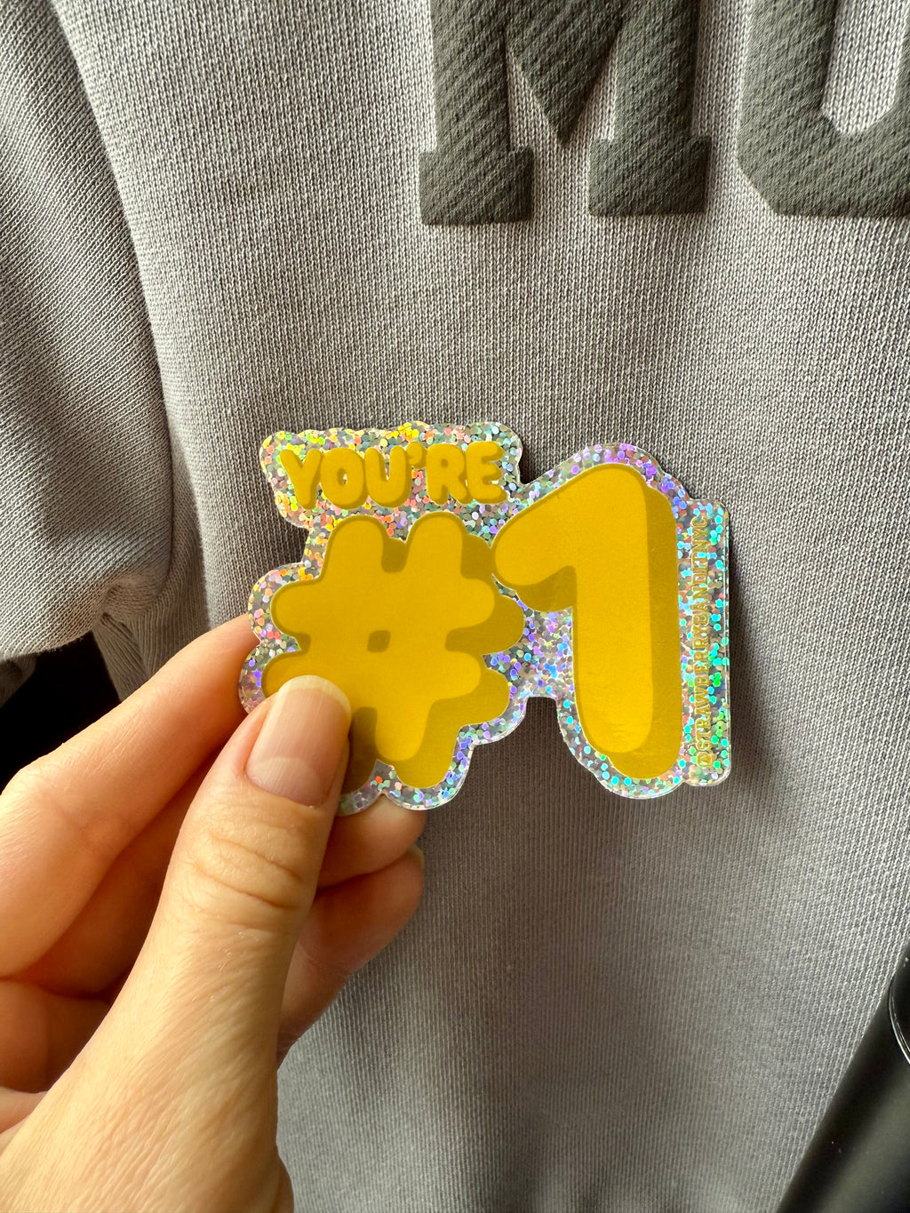 Bright yellow "YOU’RE #1" sticker by Strawberry Bandit featuring bold black text on a circular adhesive backing.