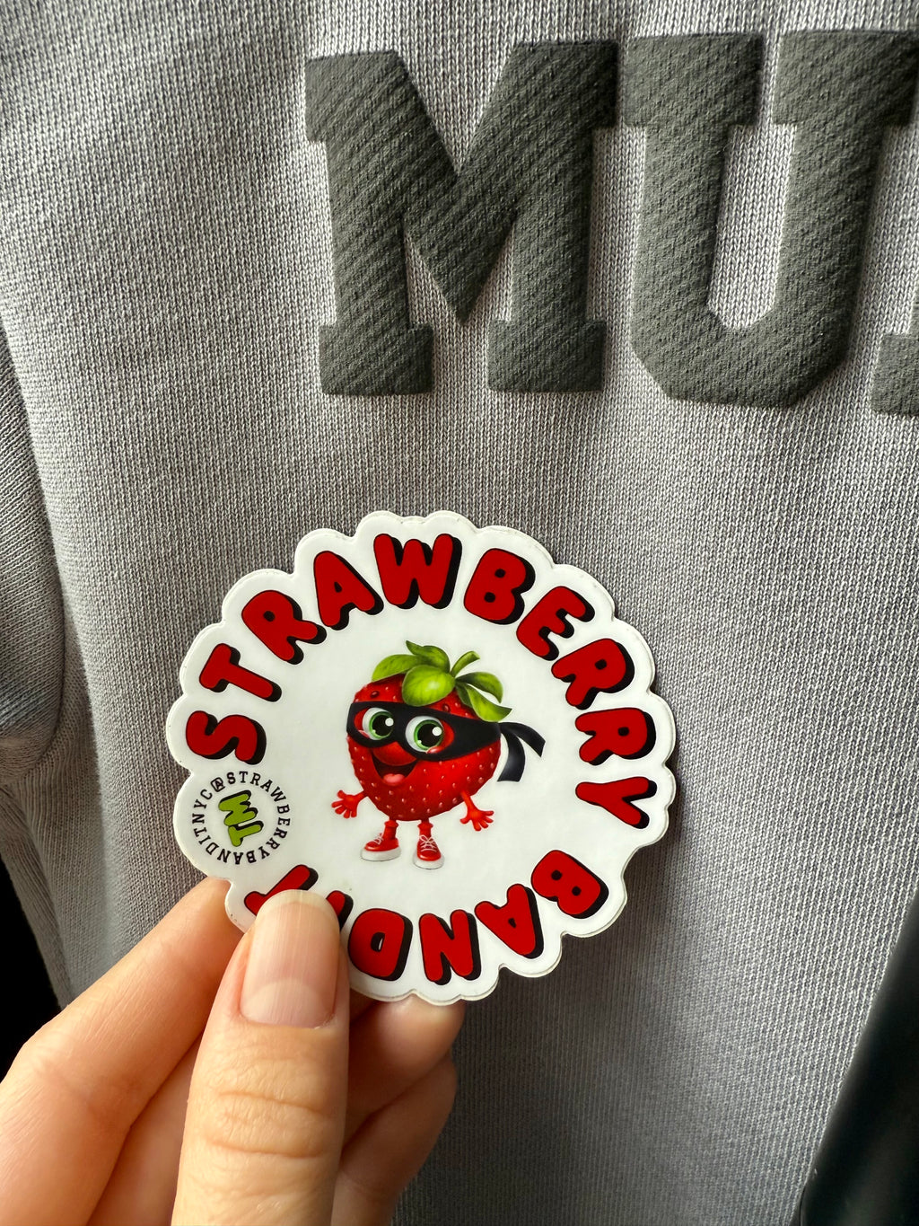 Strawberry Bandit TM sticker featuring a colorful strawberry character with playful design on a white background.